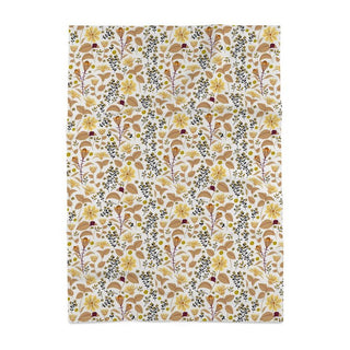 Image of tea towel with yellow Leopard's bane flowers and tan leaves with black accents against a white background
