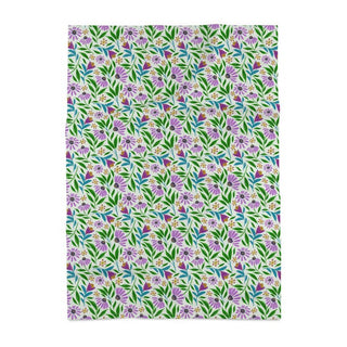 Image of tea towel with purple coneflowers and green and blue leaves on a light green background