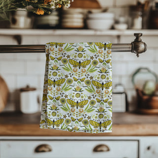 Floral and butterfly patterned towel hanging on a kitchen rack. sold online at jean c studio.