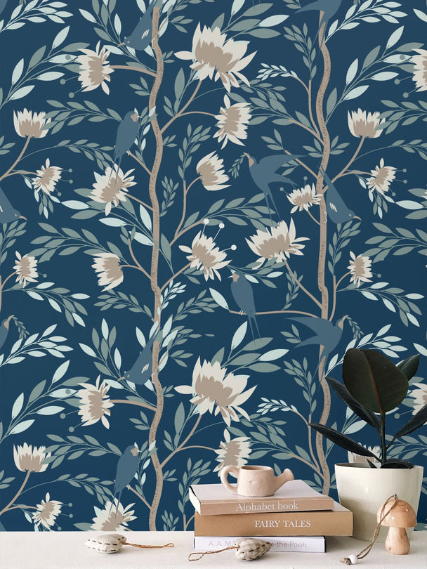 Image of wallpaper on a wall featuring stylized white and tan flowers, bluebirds and light greenish blue leaves against a medium dark teal background