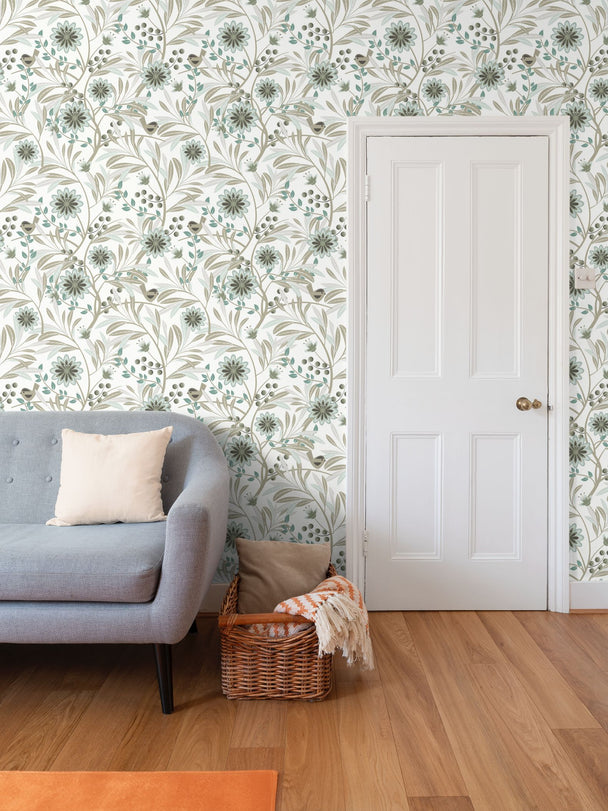 Image of wallpaper on a living room wall featuring stylized pale green flowers, pale green and tan leaves and a cute tan bird against a white background