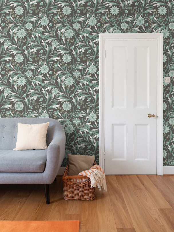 Image of wallpaper on a living room wall featuring stylized pale green flowers, leaves and a cute bird against a brown background