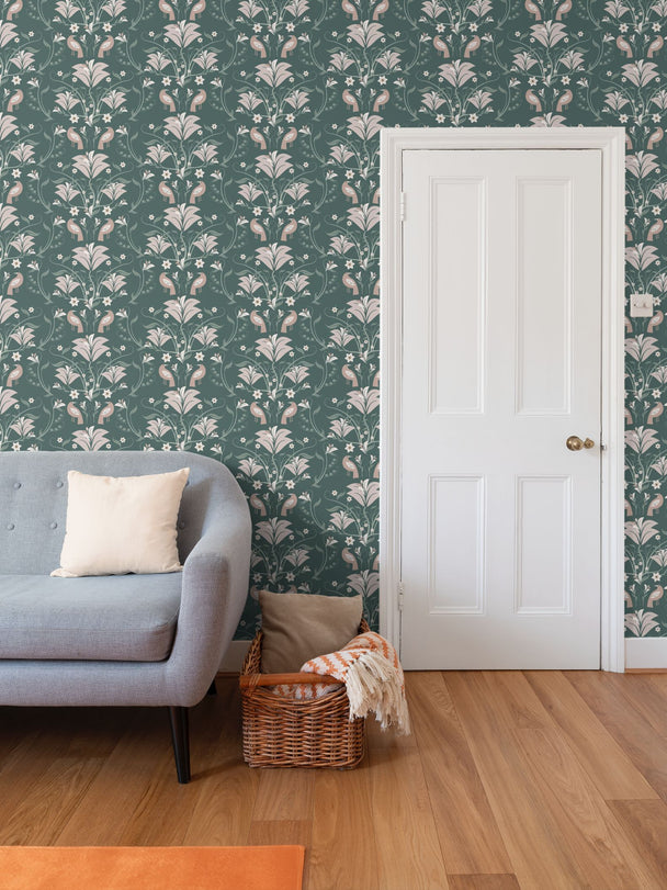 Image of wallpaper on a living room wall featuring stylized large light peachy tan  flowers and light green leaves and tan birds against a medium dark green  background