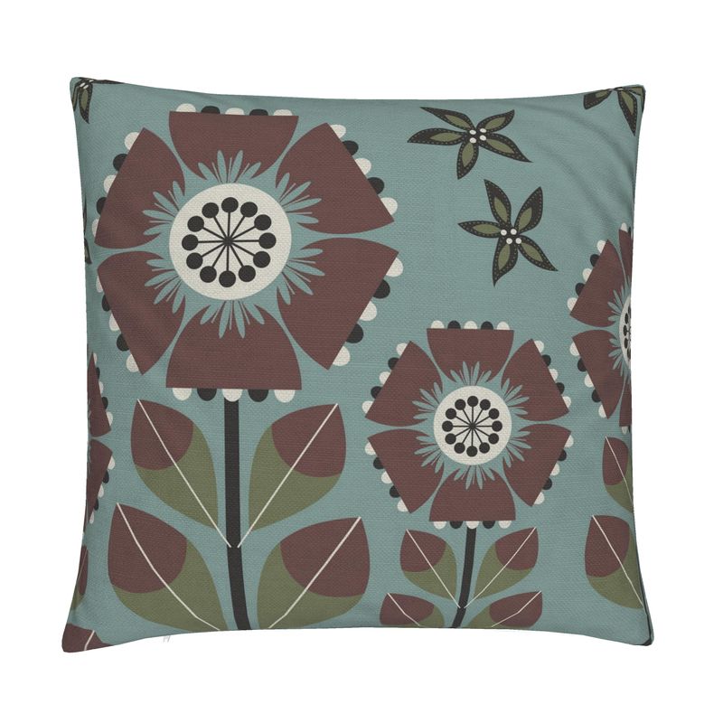 closeup image of a throw pillow. the pillow has a light teal background and 4 stylized brown and white flowers. Smaller dark green and light green flowers are in the background. 