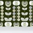 closeup image of wallpaper on a wall featuring stylized large pale  green flowers and light green and blue leaves against a medium warm green  background