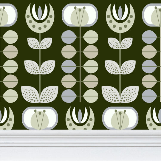 closeup image of wallpaper on a wall featuring stylized large pale  green flowers and light green and blue leaves against a medium warm green  background