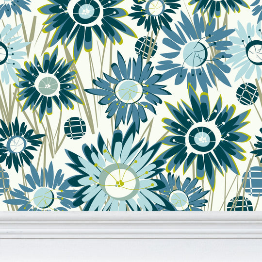 closeup image of wallpaper on a wall featuring stylized tall teal and blue asters on green stems against a pale cream background