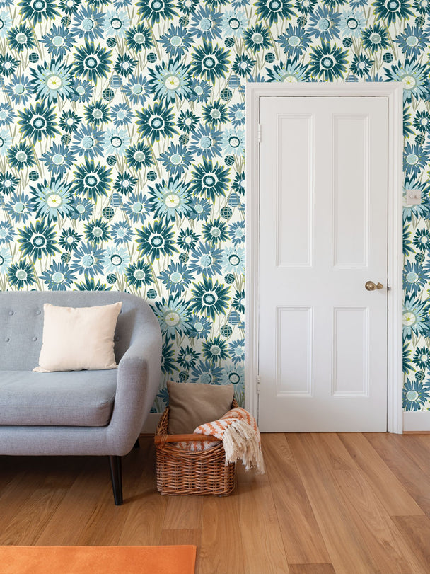 image of wallpaper on a living room wall featuring stylized tall teal and blue asters on green stems against a pale cream background