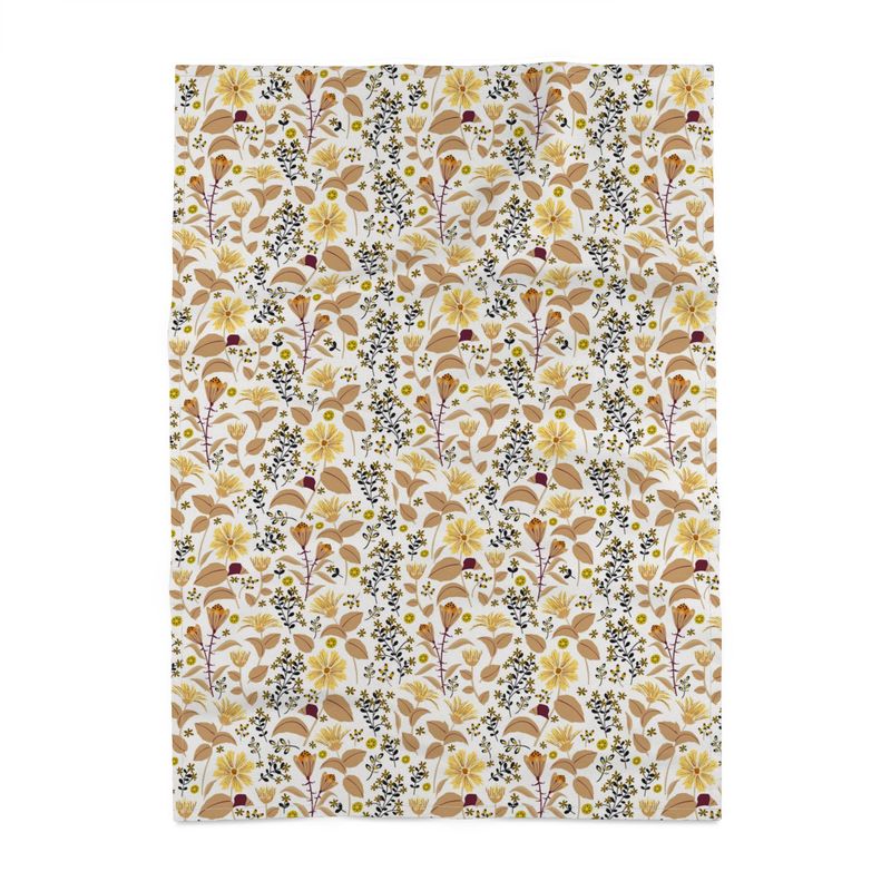 Image of tea towel with yellow Leopard's bane flowers and tan leaves with black accents against a white background