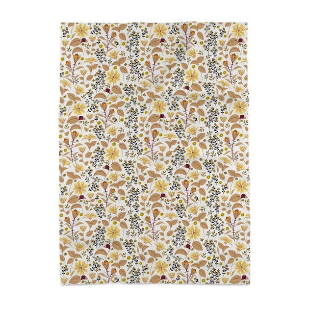 Image of tea towel with yellow Leopard's bane flowers and tan leaves with black accents against a white background