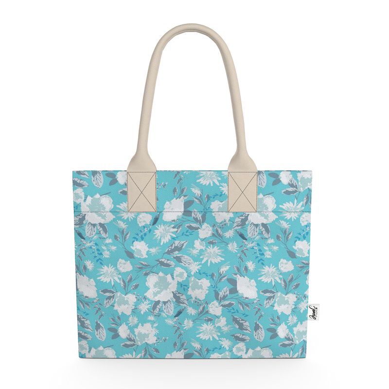 Image of tote bag with very pale blue flowers and grey blue leaves against a medium aqua blue background