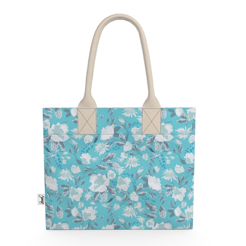 Image of tote bag with very pale blue flowers and grey blue leaves against a medium aqua blue background