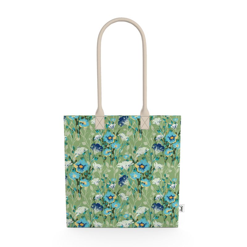 Image of tote bag with blue flowers with orange centers, white flowers, and pale green leaves against a medium green background.