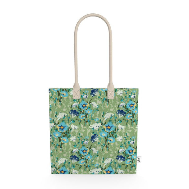 Image of tote bag with blue flowers with orange centers, white flowers, and pale green leaves against a medium green background.