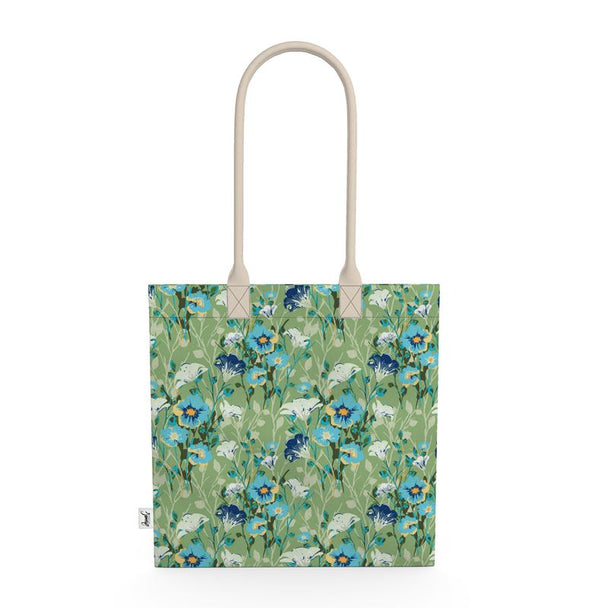 Image of tote bag with blue flowers with orange centers, white flowers, and pale green leaves against a medium green background.