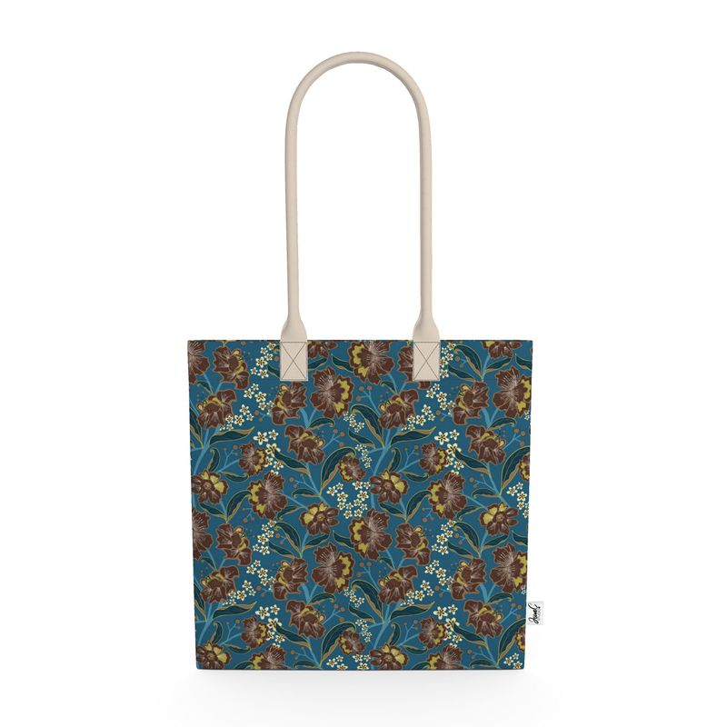 Image of tote bag with bold cocoa and gold colored flowers, teal and gold leaves, gold berries against a medium blue background.