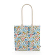Image of tote bag with flowers in gold, green, blue and orange against a white background.