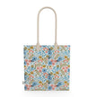 Image of tote bag with flowers in gold, green, blue and orange against a white background.