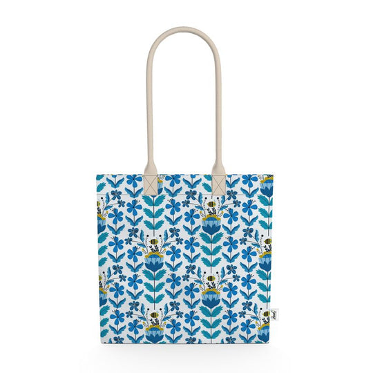 Image of tote bag with stylized blue and gold flowers, blue green leaves and bees