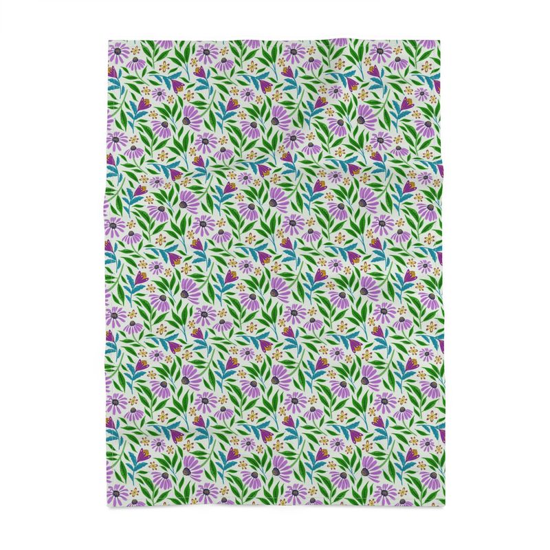 Image of tea towel with purple coneflowers and green and blue leaves on a light green background