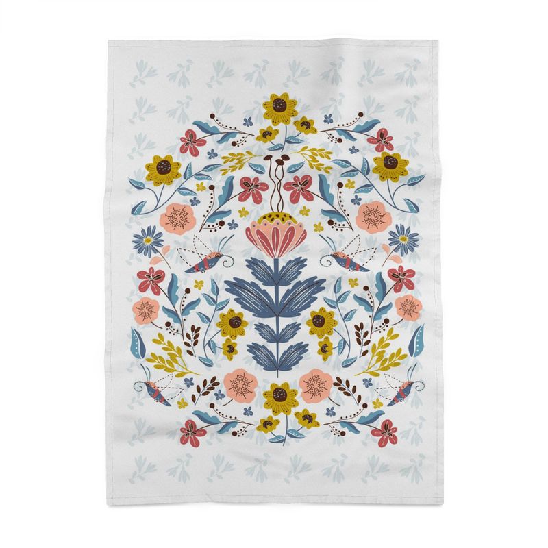 image of tea towel with illustration of flowers and hummingbird moths. In pastel colors.