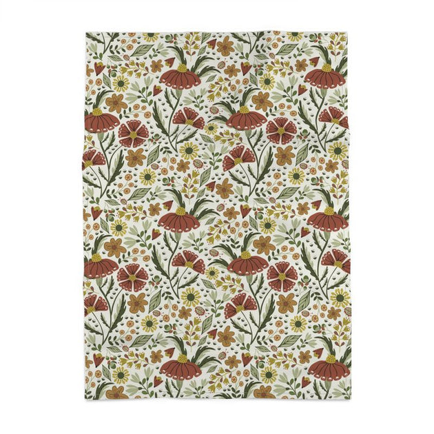 image of tea towel illustrated with flowers and ladybugs in earth tone colors