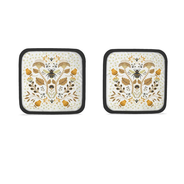 Image of two pot holders with illustration of bee and flowers in tan and orange.