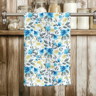 Floral patterned towel hanging on a wooden rack with jars in the background