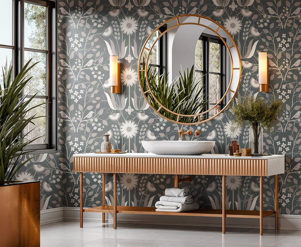 Image of wallpaper on a bathroom wall featuring stylized large pale  flowers and light tan leaves and pinkish birds against a medium slate green  background