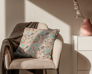 Decorative pillow with floral pattern on a chair in a softly lit room.