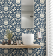 Image of wallpaper on a bathroom wall featuring stylized large white flowers and birds against a blue gray background